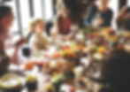 This photo shows family and friends sitting around a table eating dinner